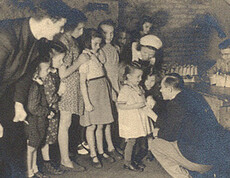 Children stand in line and receive sugar from Caritas staff—a scene from 1946