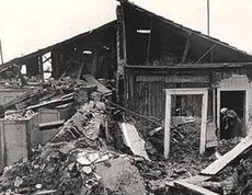 A partially collapsed house in southern Italy after the 1980 earthquake—a person is clearing debris from the building