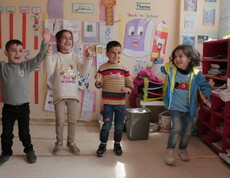 Six children take part in a coordinated group activity in a brightly decorated classroom in Lebanon.