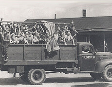 An open-bed Caritas truck with numerous children on the bed during a recreational trip in 1947