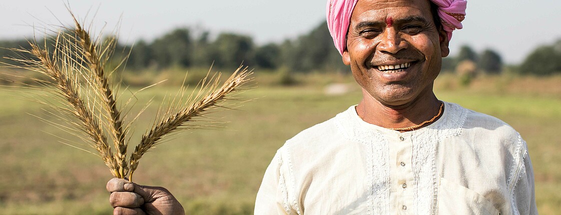 The picture shows a man holding crops